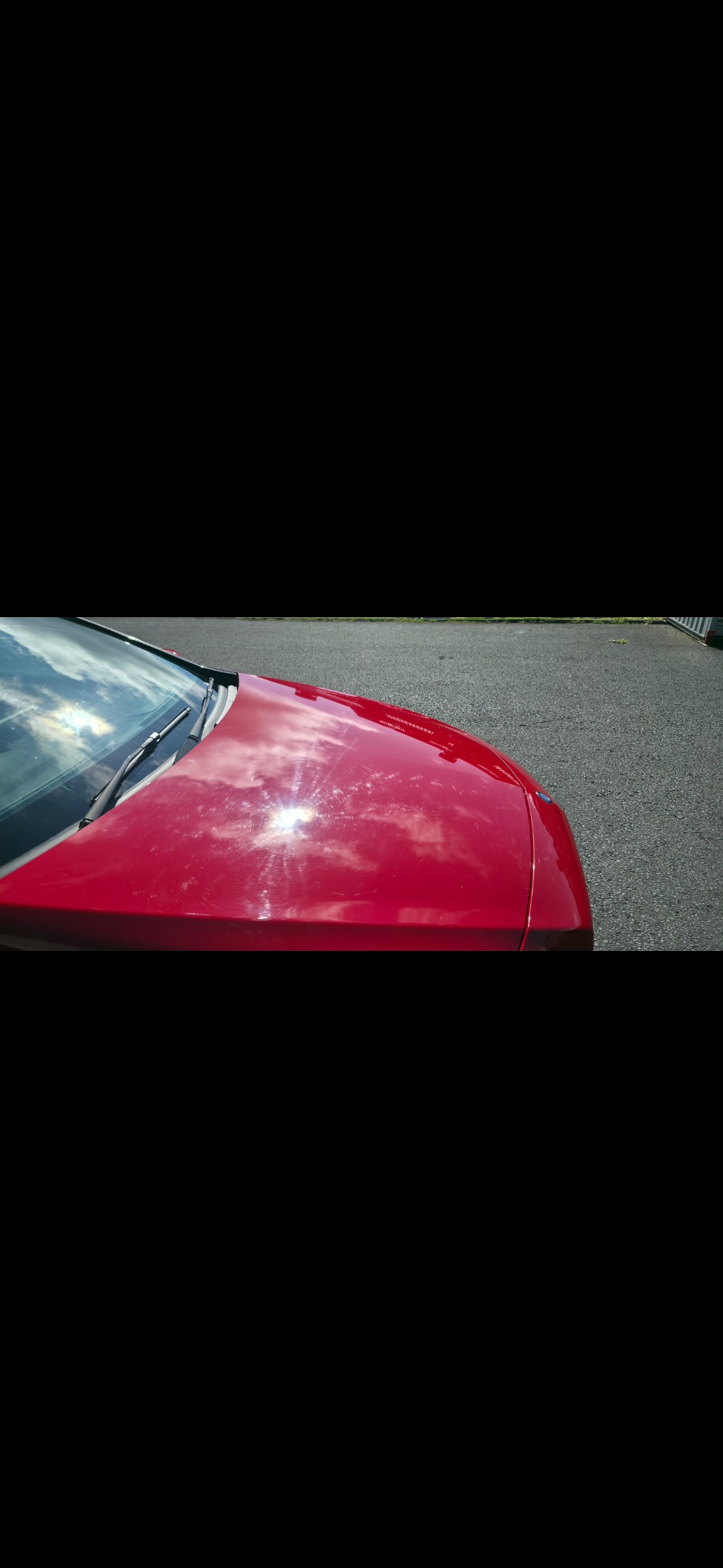 Red paintwork showing swirl marks before machine polishing